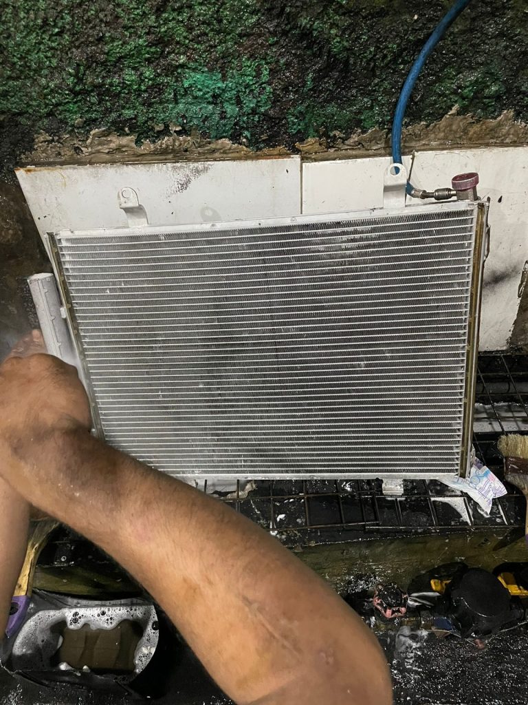 Proses membersihkan kondensor AC alat berat
